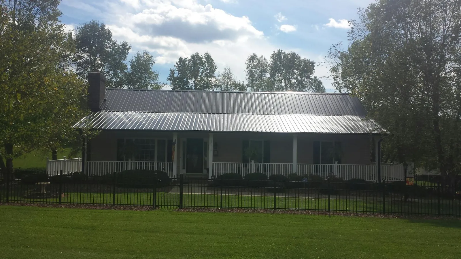Gray metal roof on a brick ranch with a full width front porch — Gutter Guard Installation work by our crew in Hanover